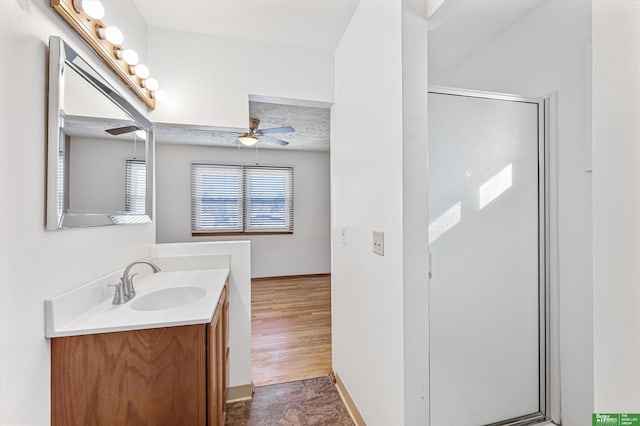 bathroom with vanity, ceiling fan, a shower with door, and a textured ceiling