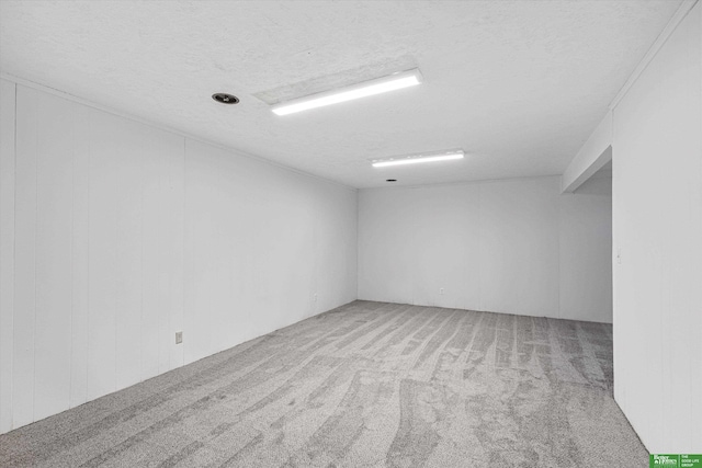 unfurnished room with light colored carpet and a textured ceiling