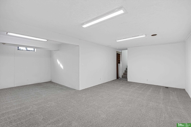 basement featuring carpet floors and a textured ceiling