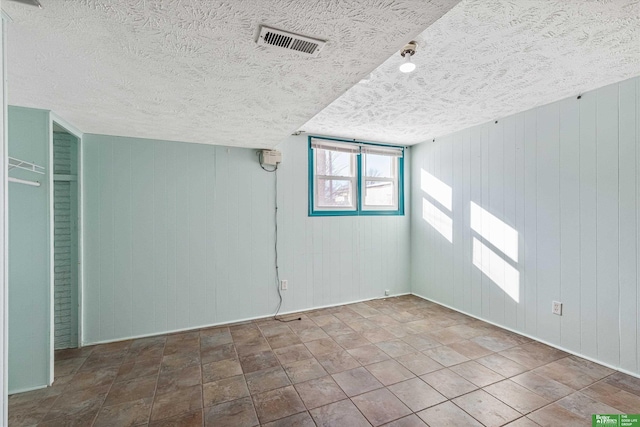 unfurnished room featuring a textured ceiling