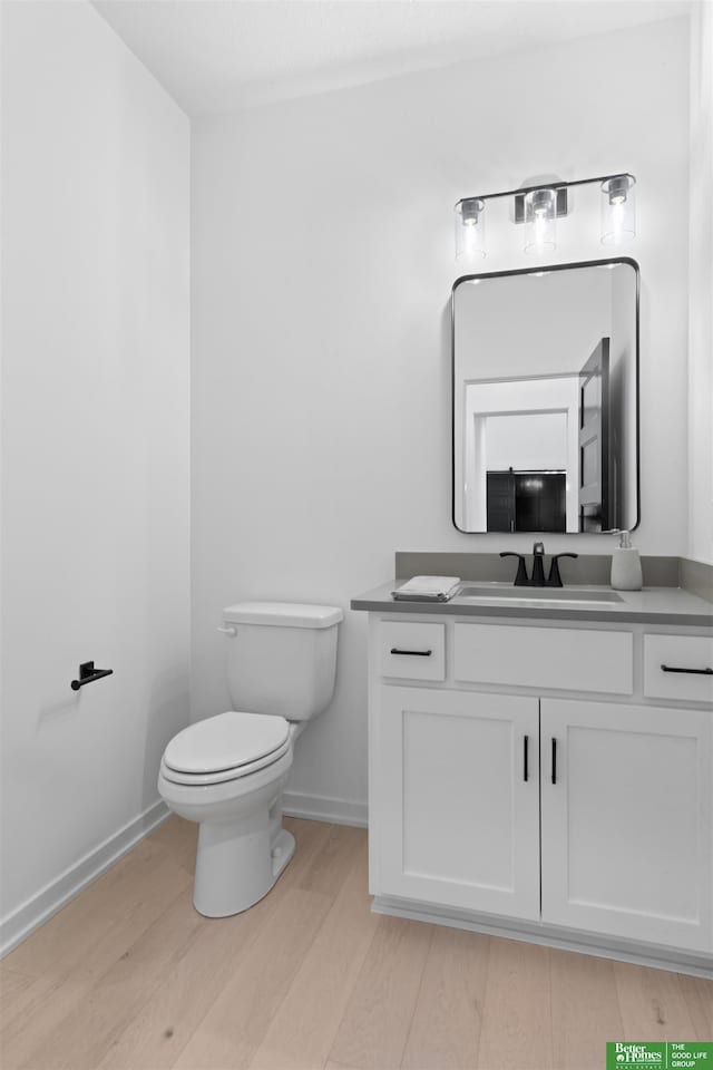 bathroom with vanity, hardwood / wood-style floors, and toilet