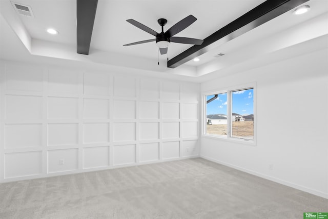 carpeted spare room with beamed ceiling and ceiling fan