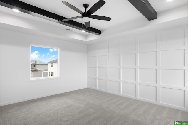 carpeted empty room with beam ceiling and ceiling fan