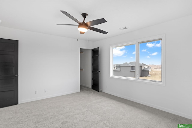 carpeted spare room with ceiling fan