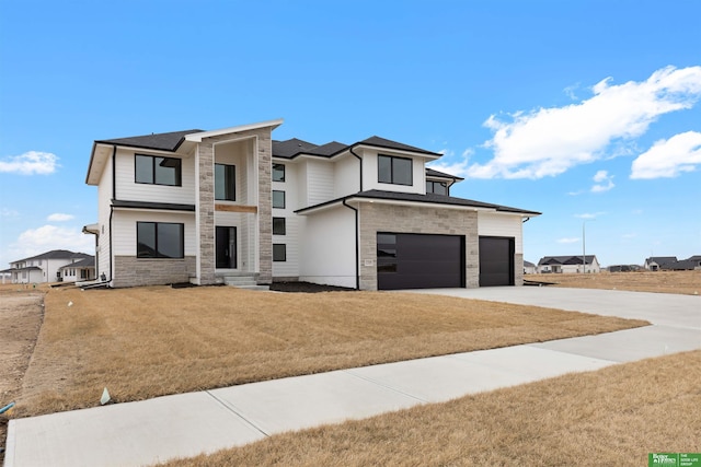 view of front of house featuring a garage and a front lawn