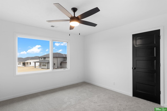 carpeted spare room featuring ceiling fan