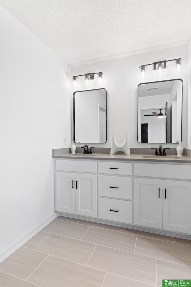 bathroom featuring ceiling fan, vanity, and a textured ceiling