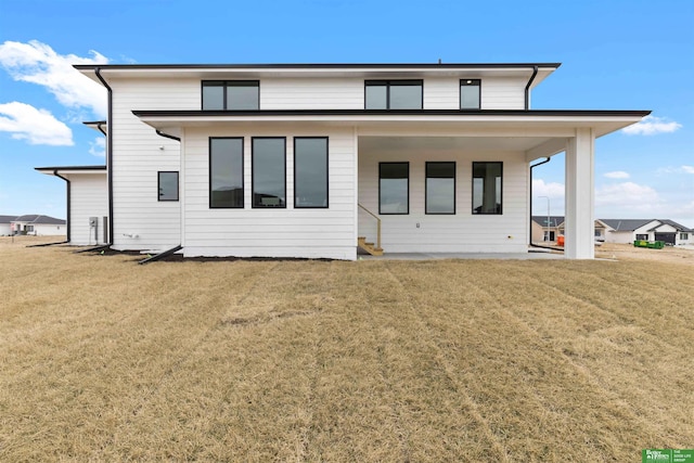 rear view of property with a lawn