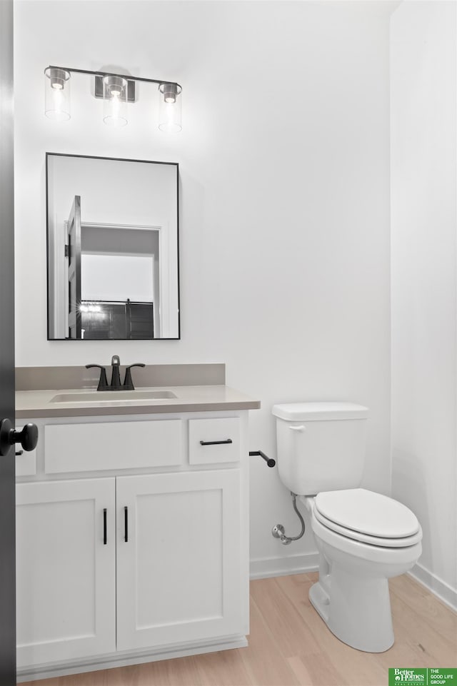 bathroom with vanity, wood-type flooring, and toilet