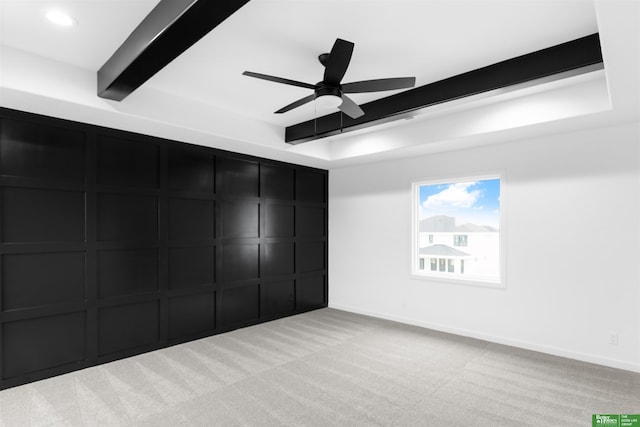 carpeted spare room with ceiling fan and beam ceiling