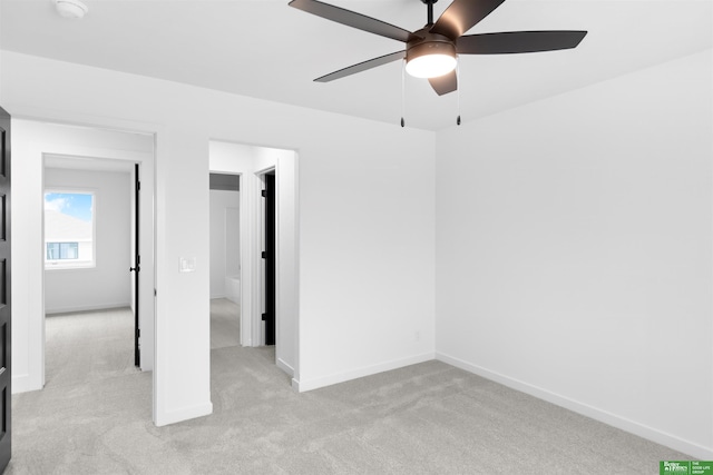 spare room with ceiling fan and light colored carpet