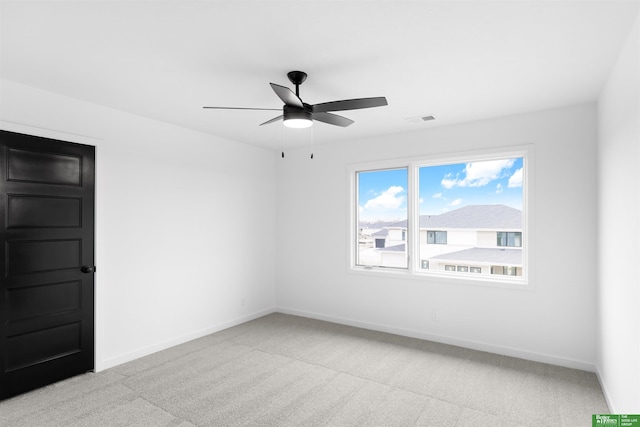 unfurnished room with ceiling fan and light carpet