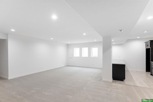 unfurnished living room with light colored carpet