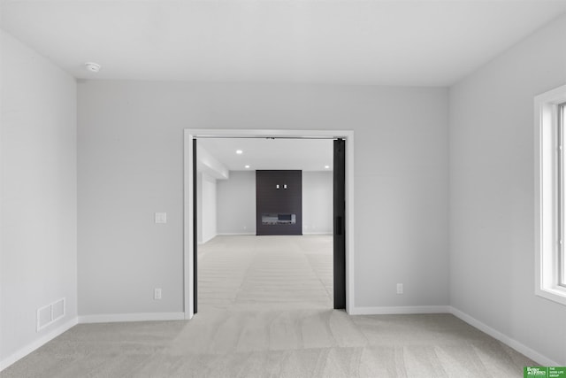 carpeted empty room with a fireplace