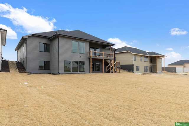 back of property featuring a wooden deck and a yard