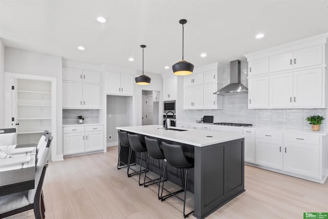 kitchen with white cabinetry and wall chimney exhaust hood