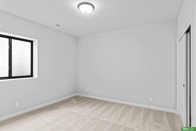 unfurnished bedroom featuring carpet flooring and a closet