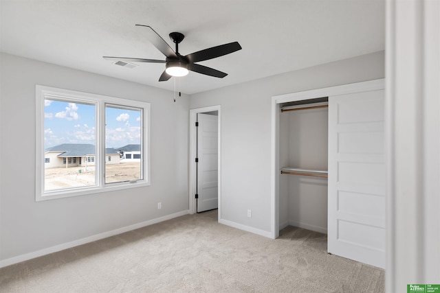 unfurnished bedroom with light carpet, ceiling fan, and a closet