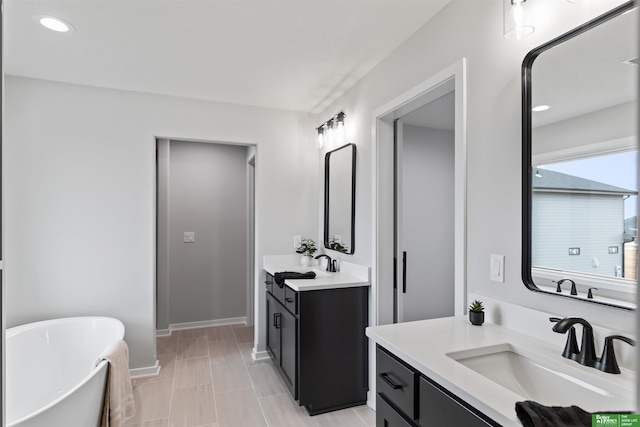 bathroom with a washtub and vanity