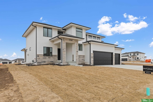 prairie-style home with a garage and a front lawn