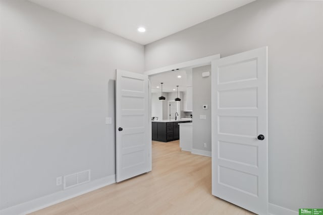 unfurnished room with sink and hardwood / wood-style floors