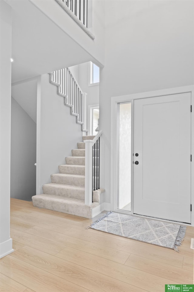 foyer entrance with light hardwood / wood-style floors and a high ceiling