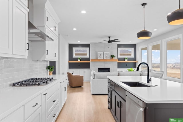 kitchen featuring stainless steel appliances, white cabinetry, sink, and decorative light fixtures