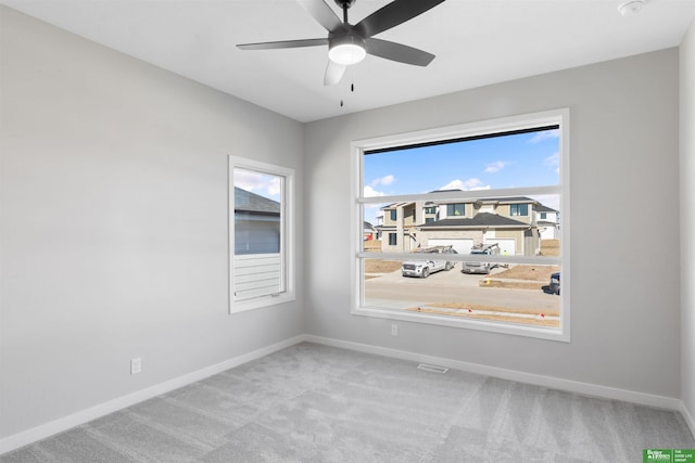 carpeted spare room featuring ceiling fan