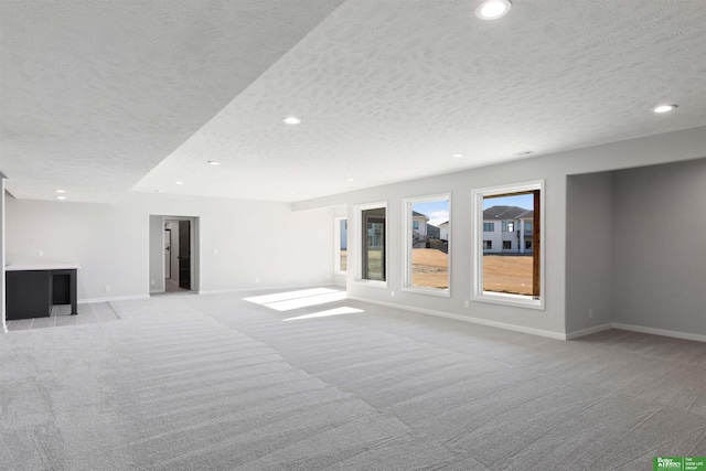 interior space with light colored carpet and a textured ceiling