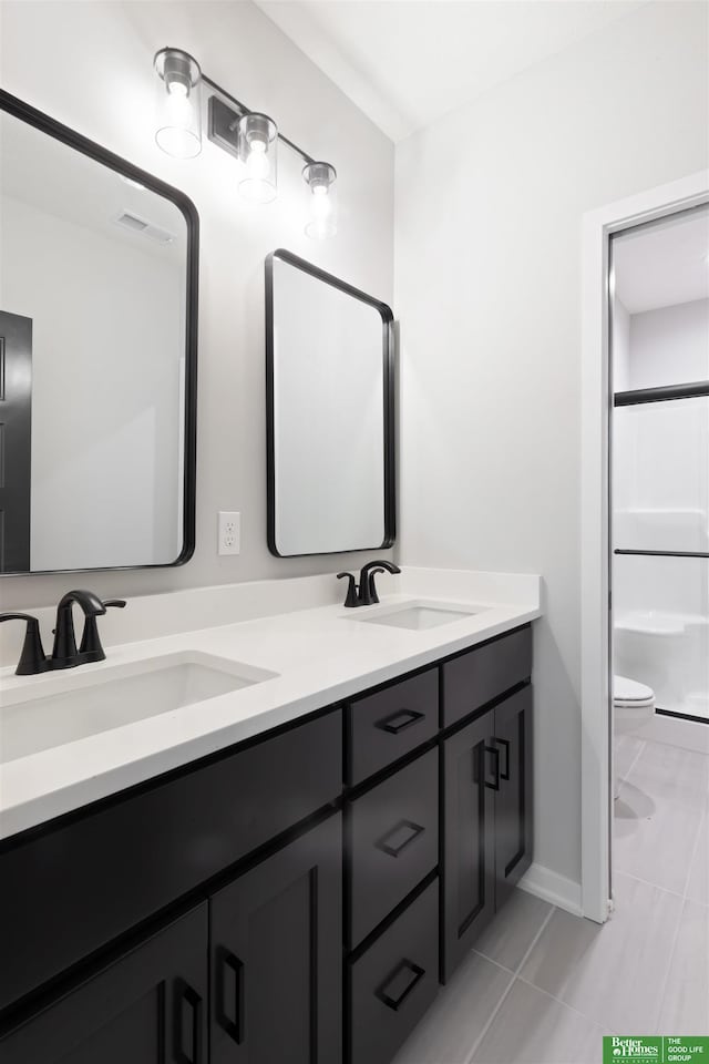 bathroom featuring tile patterned floors, vanity, toilet, and a shower