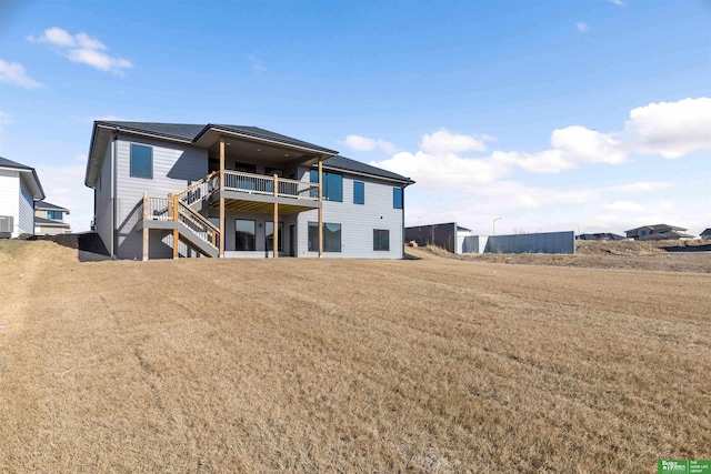 rear view of property featuring a deck and a lawn