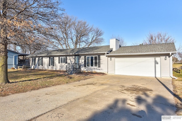 ranch-style house featuring a garage and a front lawn