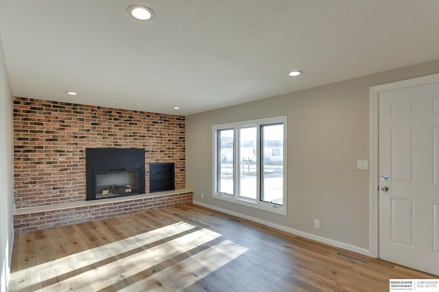 unfurnished living room with a fireplace and light hardwood / wood-style flooring