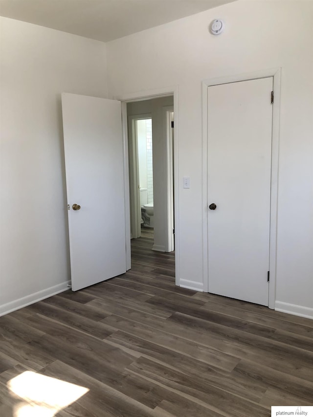 empty room featuring dark wood finished floors and baseboards