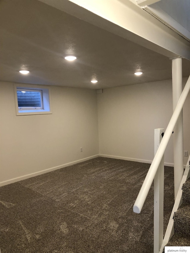 finished below grade area featuring stairs, recessed lighting, dark carpet, and baseboards