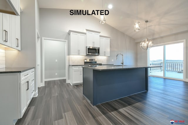 kitchen featuring appliances with stainless steel finishes, decorative light fixtures, white cabinetry, sink, and dark wood-type flooring