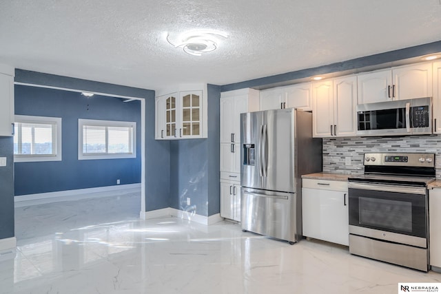 kitchen featuring tasteful backsplash, white cabinetry, appliances with stainless steel finishes, and a textured ceiling