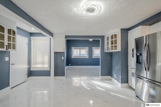 kitchen featuring white cabinets, a textured ceiling, and stainless steel fridge with ice dispenser