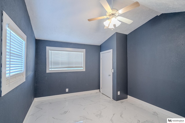 unfurnished bedroom with ceiling fan, vaulted ceiling, and a textured ceiling