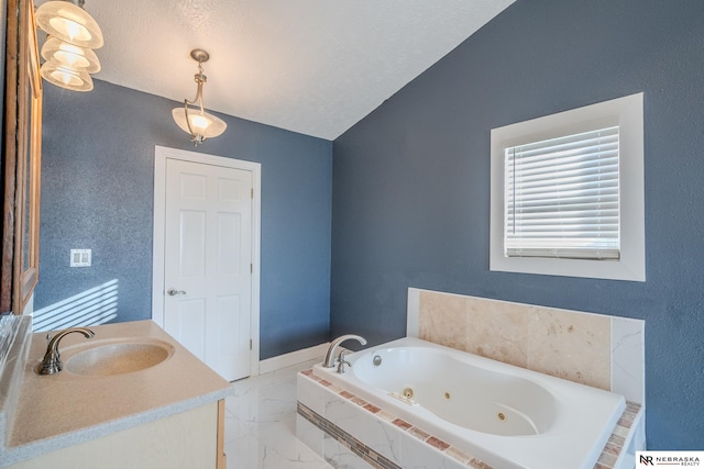 bathroom featuring tiled tub, vanity, lofted ceiling, and a textured ceiling