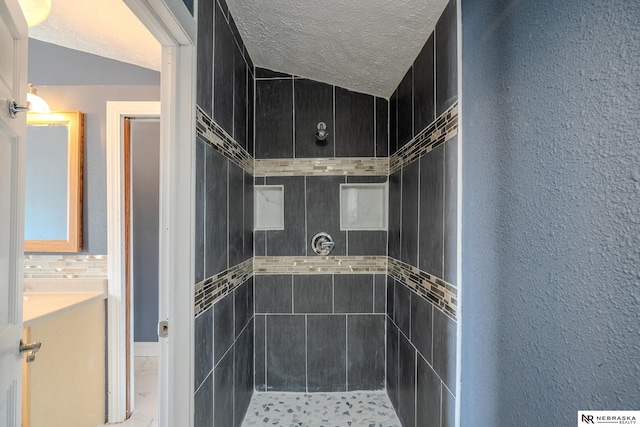 bathroom featuring tiled shower and a textured ceiling