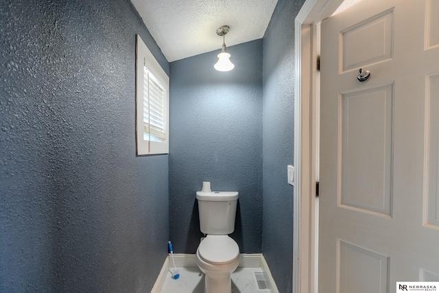 bathroom featuring tile patterned floors, toilet, and a textured ceiling