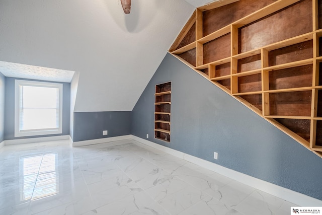 bonus room featuring vaulted ceiling and a textured ceiling