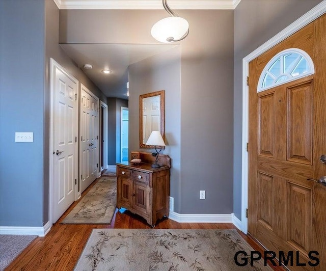 entryway with crown molding and light wood-type flooring