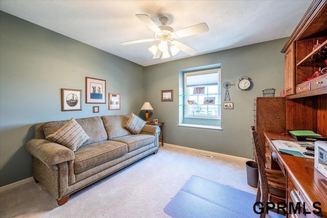 carpeted office space with ceiling fan