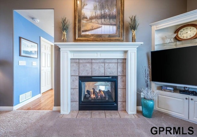 room details with a tile fireplace and carpet floors