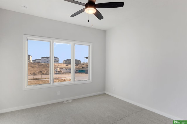 carpeted spare room with ceiling fan