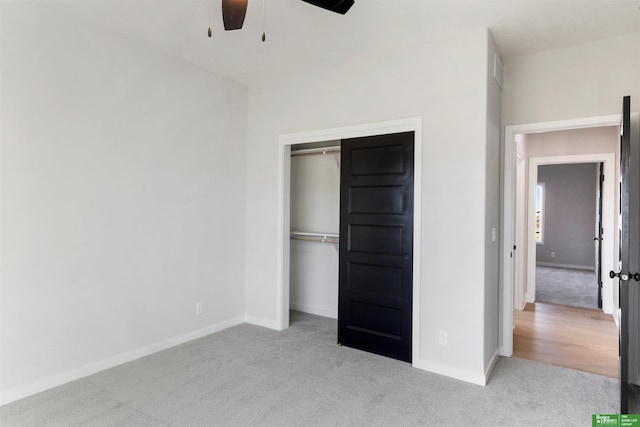 unfurnished bedroom with light colored carpet, ceiling fan, and a closet