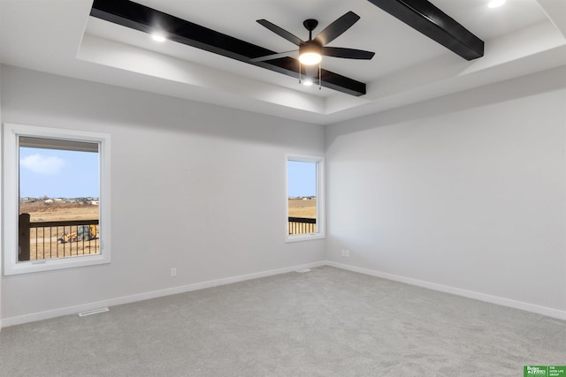 carpeted spare room featuring beamed ceiling and ceiling fan