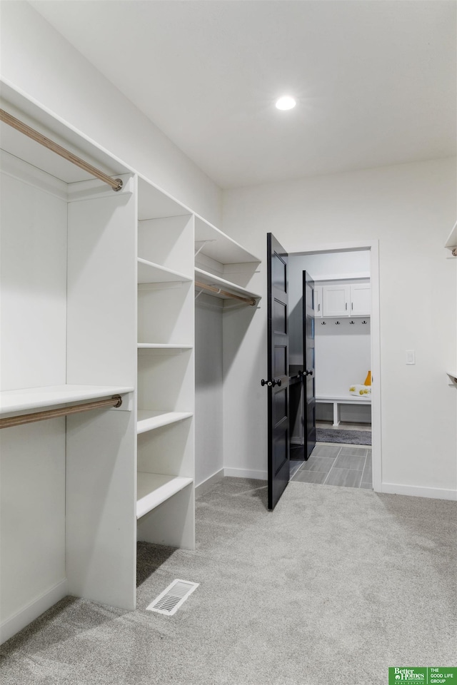 walk in closet featuring light carpet